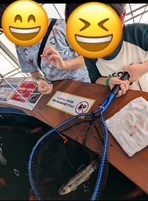 釣り堀で、魚を網に上げている写真
