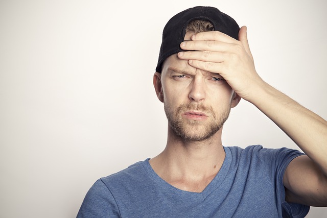 男性が、手を額に当てて悩んでいる様子