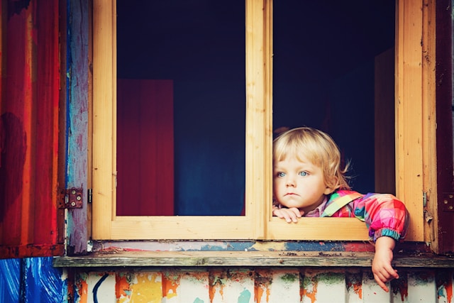 子供が家の中から、外の様子を見ている状況。