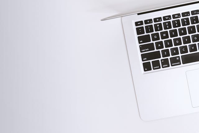 白いテーブルの上にMacbookがおかれている様子
